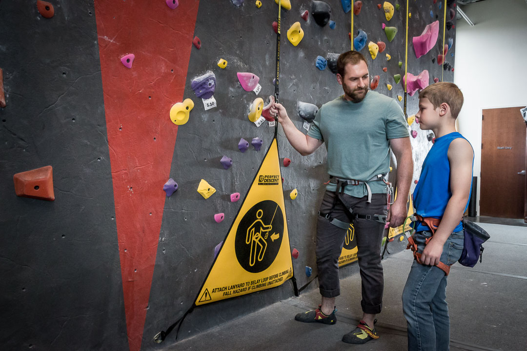 son and father at a rock climbing gym using perfect descent auto belays