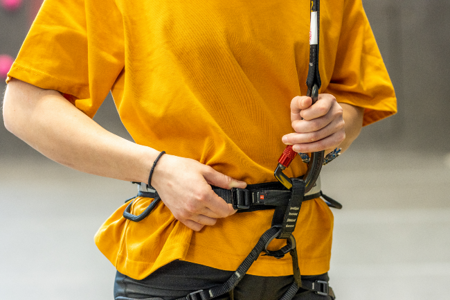 INSPECT1 Climber inspects their harness and connection to Perfect Descent Auto Belay